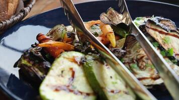 melanzana zucchine carote grigliato verdure su un' nero piatto, gustoso e appetitoso presentazione video