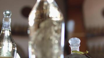 cristallo chiaro Vodka bellissimo servendo di alcolizzato bevande azienda vinicola nel un' di legno barile bicchiere bottiglia con diverso erbe aromatiche video