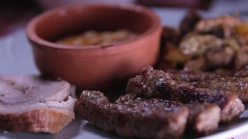 grigliato lula kebab su spiedo su griglia, barbecue, patate cunei, dolce Pepe, caldo getto ferro grattugiare. vicino su. video