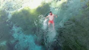 azul ojo Albania 25.03.2024 hombre nadando en Tormentoso agua 50 metros profundo en el azul ojo o siri yo kalter, un natural fenómeno en el montañas de del Sur Albania video