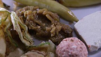 salada com tomates pão com queijo grelhado abobrinha, grelhado pimentas dentro uma restaurante dentro macedônia, Comida é servido em uma vermelho quadrado toalha de mesa. video