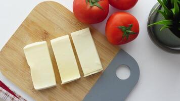 Slicing cheese into pieces closeup, video