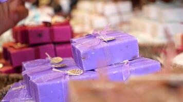 woman hand pick purple soaps with blue ribbons in a basket video