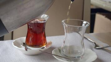 fills Turkish tea into a glass video