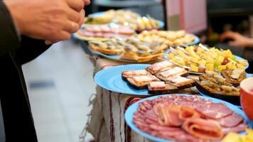 buffet maken een belegd broodje plakjes van varkensvlees ham Aan houten bord, maken broodje, ingrediënten Aan achtergrond, dolly schot video