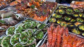 vendedores vender recentemente grelhado frutos do mar às uma noite mercado dentro Chiang mai. video