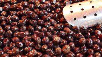 slices black olives with spoon in a bowl , video