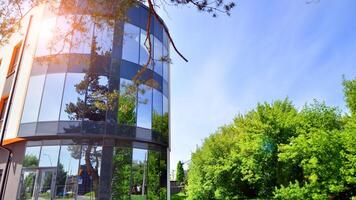 Sustainable glass office building with trees for reducing carbon dioxide. Eco-friendly building in modern city. Office with green environment. Corporate building reduce CO2. photo