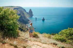 A woman is walking on a beach near the ocean photo