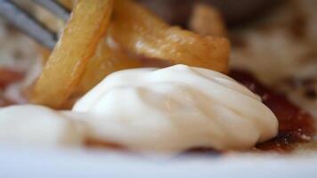 detalhe tiro do francês fritas bebericando maionese em mesa video