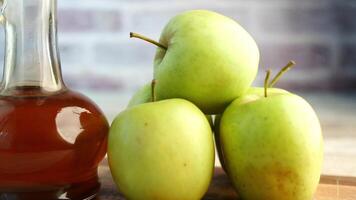 apple vinegar in glass bottle with fresh green apple on table video