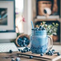 A fruit smoothie on a work table in a boho-style office photo