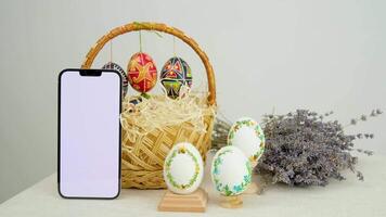 against the background of a shopping cart phone white screen Easter eggs Lavender lavender background postcard baner calendar empty space holiday easter eggs embroidery ribbons on eggshell krashanka video