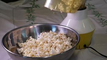 emocionante palomitas de maiz con un cuchara de cerca en un hierro cuenco preparando palomitas de maiz para un noche película visita video