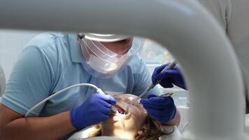 neueste Technologie Reinigung und Bleaching Zähne Krankenschwester und Arzt Behandlung Zähne von weiblich geduldig Teenager. neueste Gerät im ein Dental Büro im ein Klinik nehmen Pflege von Zähne Schneewittchen Lächeln video