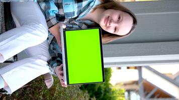 Tonårs flicka i händer med bärbar dator grön skärm krom nyckel annons tonåring sitta på veranda på Hem söt ansikte anbud leende ad se här välja detta härlig produkt nöjd Lycklig Bra utseende verklig människor video