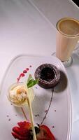 chocola fondant met aardbeien, chocola fondant met aardbeien en lepel Aan bord, geïsoleerd Aan wit achtergrond, top visie video