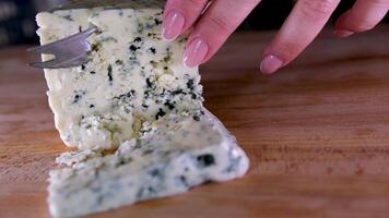 rotação queijo em Preto ardósia placa. delicioso queijo Dorblu em a corte borda em fundo video