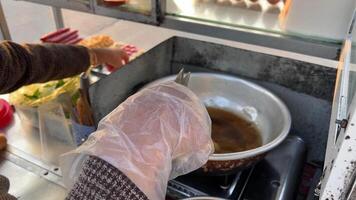 Cheap street food in Vietnam buy a bun Vietnamese woman stuffing a bun with different ingredients to fry Overcooked bad food is bad for health and dangerous video