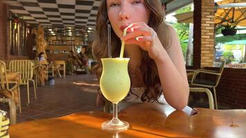 jung Mädchen im ein Weiß Kleid beim ein Resort Frau Trinken Avocado Smoothie video