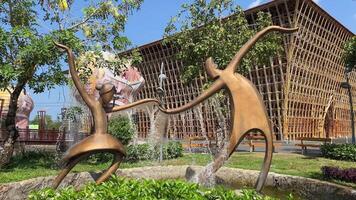 Vietnam phu quoc Insel großartig Welt 18.03.2024 Bronze- Skulptur Wasserfall Tanzen Paar auf ein Hintergrund mit ein Bambus Gebäude ohne Nägel Vietnam großartig Welt phu ok. Skulpturen video