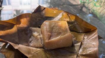 nieuw jaar rijst- taart Vietnam Vietnamees chung taart kleverig kleverig rijst- taart, gevuld met varkensvlees vlees, groen bonen en verpakt in bamboe blad. traditioneel Vietnamees nieuw jaar tet voedsel. video
