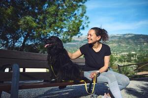 Cute black cocker spaniel dog sitting near his family on the bench in mountains nature photo