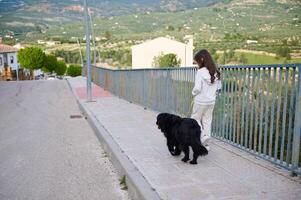 Full length authentic portrait of adorable little child girl with her dog on the walk outdoors photo