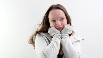 el niña es sentado y sonriente. apoyo tu cabeza con tu manos. video