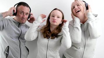 good positive-psychological relations in the family approval teenage girl dancing on a white background in headphones the girl shows the movement of the parents raise their thumbs up they like video