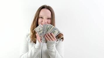 show off large amount of money young teen girl shows whole wad of money steal take from parents make money. on white background in studio 100 dollar bills and young woman with long hair in sportswear video