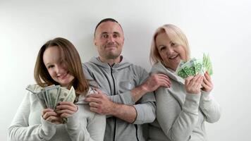 Lycklig rik familj dollar och euro i händer av mamma döttrar pappa far kramar leende Lycklig vinka pengar tycka om fläkt på vit bakgrund en massa av pengar tur resa i spel kissing släktingar på de huvud video