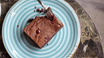 cutting a brownie with a fork on plate on table video