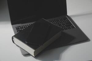 Office workplace with text space, White wooden table with office supplies tablet, desktop computer and book, top view, over light photo