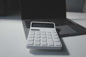 Flat lay, top view office table desk. Workspace with calculator,pen,laptop on white background.Copy Space for text,Empty Blank to word.Business Finance,Education Technology.Work from home. photo