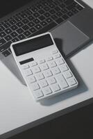 Flat lay, top view office table desk. Workspace with calculator,pen,laptop on white background.Copy Space for text,Empty Blank to word.Business Finance,Education Technology.Work from home. photo