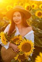 un niña en un sombrero en un hermosa campo de girasoles en contra el cielo en el noche ligero de un verano puesta de sol. rayos de sol mediante el flor campo. natural antecedentes. foto