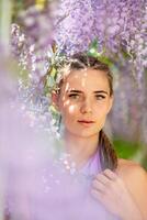 Woman wisteria lilac dress. Thoughtful happy mature woman in purple dress surrounded by chinese wisteria photo