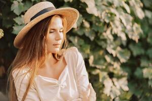 mujer con Paja sombrero soportes en frente de viñedo. ella es vistiendo un ligero vestir y posando para un foto. viaje concepto a diferente países foto