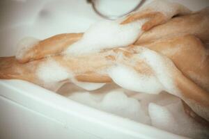 Women's feet in bath foam. View from above. Enjoy and relax in a spa hotel photo