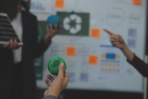 negocio personas teniendo consulta acerca de viento energía a empresa oficina. negocio equipo que se discute acerca de molino y alternativa verde energía. ejecutivo reunión a moderno oficina foto