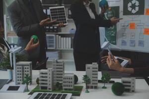 Business people having consultation about wind energy at company office. Business team discussing about windmill and alternative green energy. Executive meeting at modern office photo