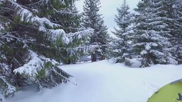 aéreo ver de viajero cerca un tienda en el montañas en invierno. hermosa invierno paisaje. viaje concepto. 4k video