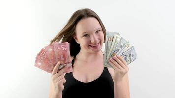 Jeune fille dans mains avec billets de banque fait du choix américain dollar et Canada dollar argent échange. billets de banque pack empaqueter. économie, concours, crise, conflit rivalité finance. Remarques bouclable sans couture video