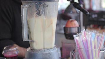 Person making smoothie in blender with food and liquid in kitchen appliance video