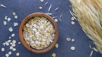 roasted oats flakes in a bowl on black background video