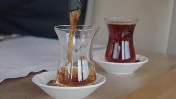 fills Turkish tea into a glass video