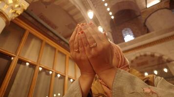 Muslim young woman in hijab is praying in mosque. video