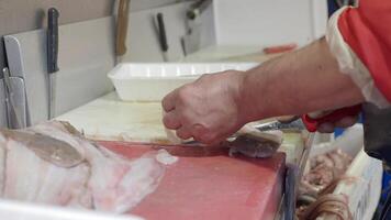 using knife slicing a fresh fish on wooden chopping board . video