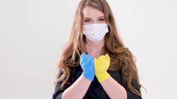 Nee oorlog dokter Holding handen met verspreiding vingers geel en blauw handschoenen hou op de oorlog Russisch agressie Oekraïne zullen winnen zege van oekraïens mensen oekraïens vlag in kleren wit studio achtergrond video